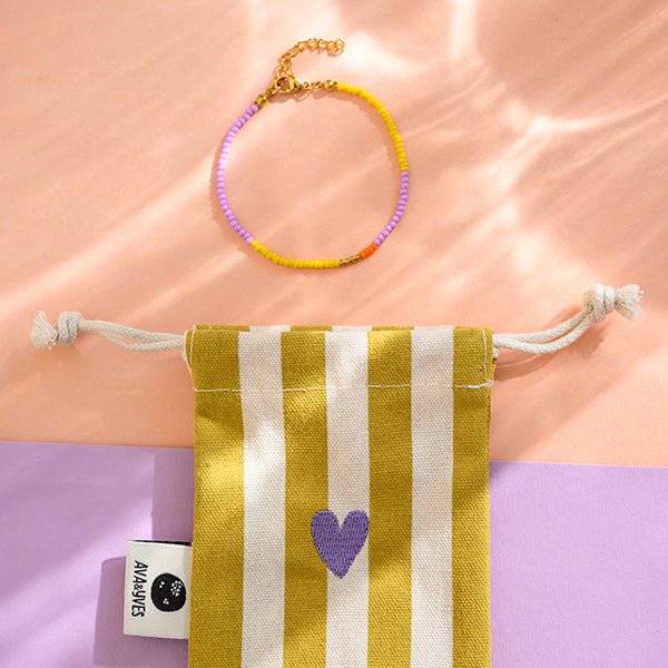 Perlenarmband lila/gelb mit Karabinerverschluss und Säckchen