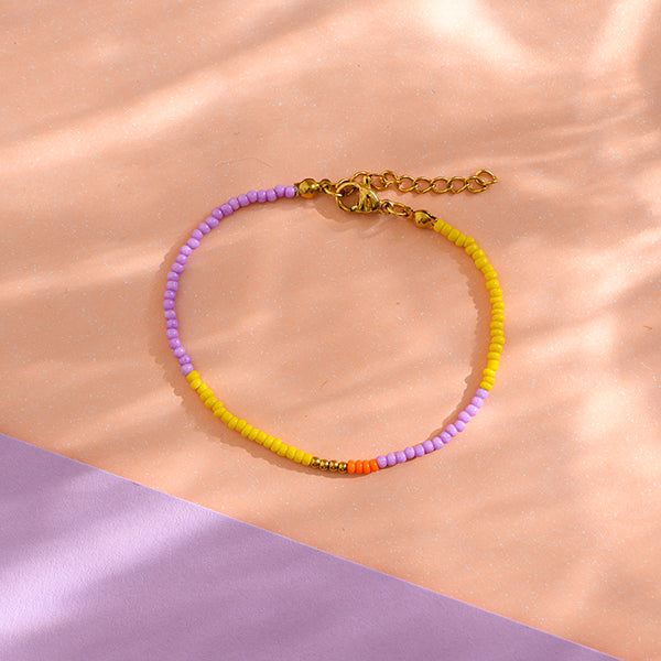 Perlenarmband lila/gelb mit Karabinerverschluss und Säckchen
