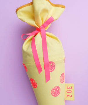 Schultüte aus Stoff in Gelb mit pinkem Smiley-Motiv zur Einschulung, handbestempelt