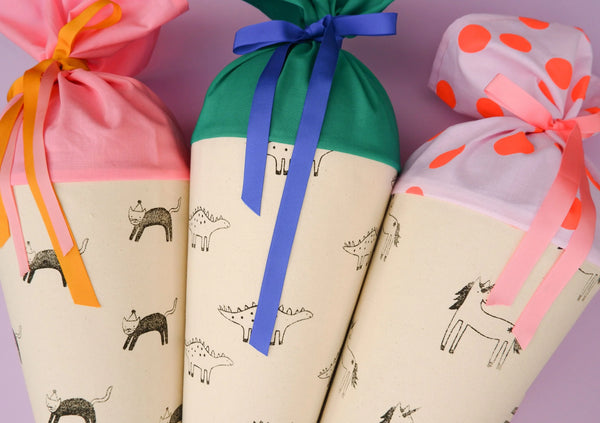 Detailansicht der drei Schultüte aus Stoff mit liebevoller Illustration: Katze, Dino und Einhorn
