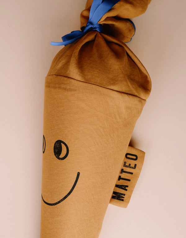 Schultüte Happy, curry-Farben, gestempeltem Gesicht zur Einschulung, mit Namenslabel an der Seite