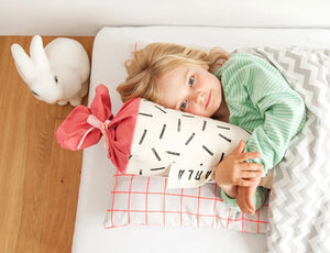 Mädchen kuschelt mit ihrer Schultüte. Motiv Strich